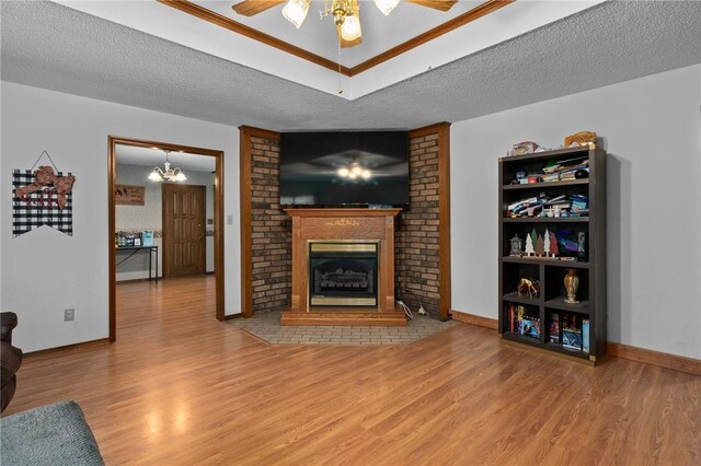 319 Belle Ave, Alma, AR 72921 - living area featuring wood finished floors, a ceiling fan, a chandelier, a fireplace, and a textured ceiling