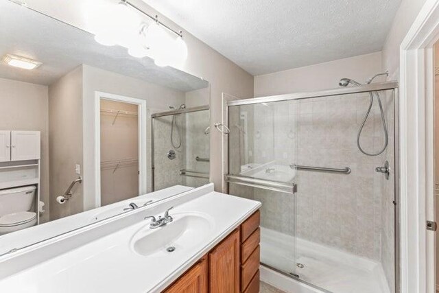 150 Cedar Wood Ave, Branson, MO 65616 - full bathroom featuring vanity, a stall shower, a spacious closet, and a textured ceiling