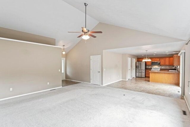 150 Cedar Wood Ave, Branson, MO 65616 - unfurnished living room with a ceiling fan, high vaulted ceiling, light colored carpet, and a chandelier