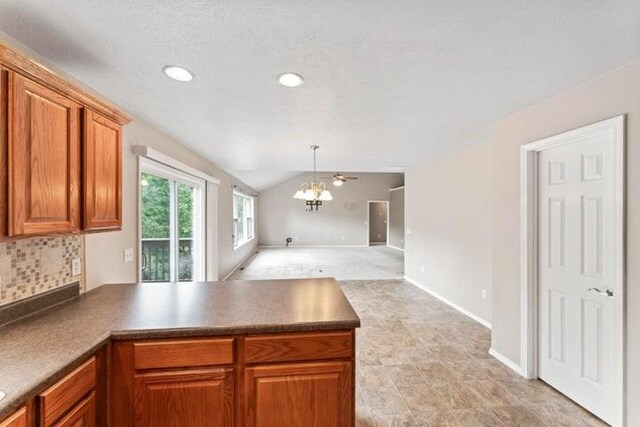 150 Cedar Wood Ave, Branson, MO 65616 - kitchen with a peninsula, brown cabinets, lofted ceiling, backsplash, and open floor plan