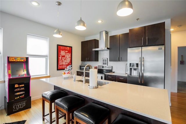3901 W 5th St, Fayetteville, AR 72701 - kitchen with wall chimney range hood, appliances with stainless steel finishes, light wood-style floors, light countertops, and recessed lighting