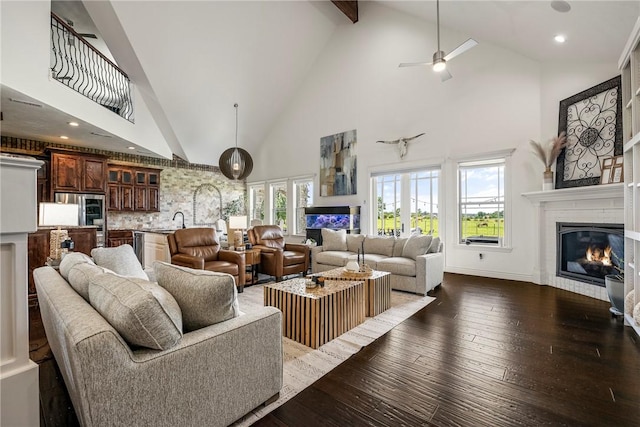 11267 Walters Rd, Bentonville, AR 72712 - living room featuring high vaulted ceiling, a glass covered fireplace, healthy amount of natural light, ceiling fan, and dark wood-style flooring