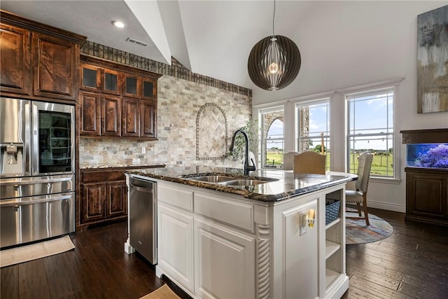 11267 Walters Rd, Bentonville, AR 72712 - kitchen with stainless steel appliances, dark stone counters, vaulted ceiling, dark wood-style flooring, and decorative backsplash