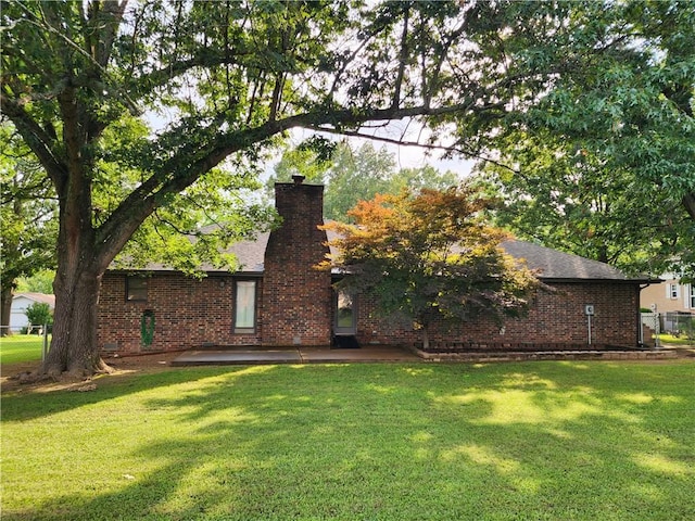 1805 Van Buren Ave, Mountain Home, AR 72653 - view of front of house featuring brick siding, a front yard, a chimney, and a patio