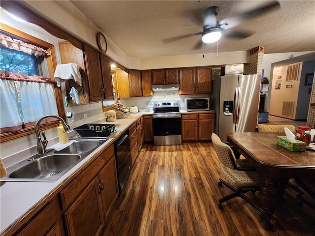 1805 Van Buren Ave, Mountain Home, AR 72653 - kitchen with appliances with stainless steel finishes, dark wood finished floors, a textured ceiling, a ceiling fan, and under cabinet range hood
