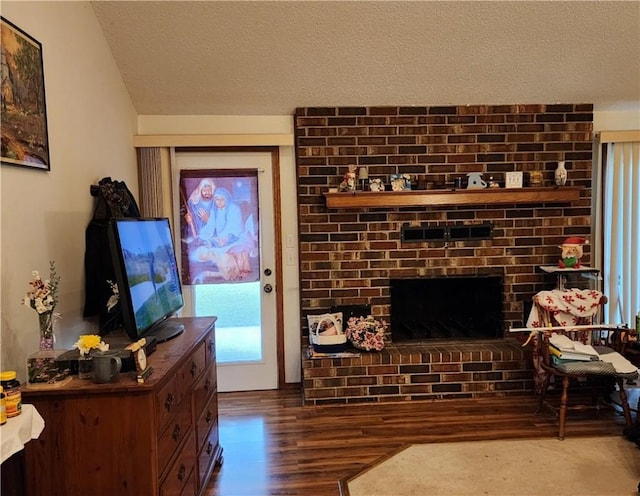1805 Van Buren Ave, Mountain Home, AR 72653 - living room with wood finished floors, a textured ceiling, and a brick fireplace