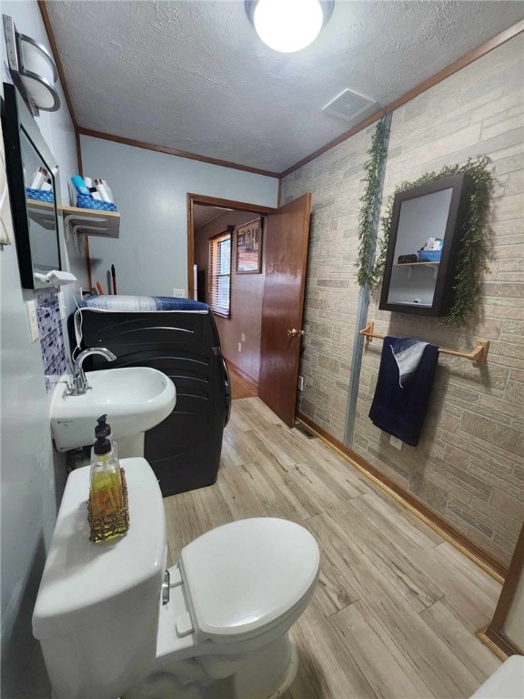 46 Hathcoat Rd, Harrison, AR 72601 - bathroom with washer / clothes dryer, ornamental molding, wood finished floors, and a textured ceiling