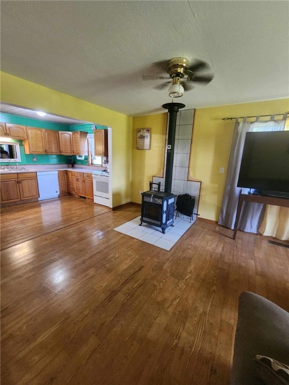 46 Hathcoat Rd, Harrison, AR 72601 - living area featuring wood finished floors, a wood stove, a ceiling fan, and a textured ceiling
