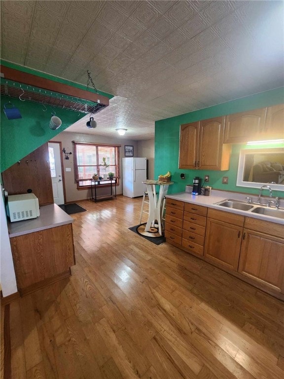 46 Hathcoat Rd, Harrison, AR 72601 - kitchen with freestanding refrigerator, light wood-style flooring, light countertops, an ornate ceiling, and brown cabinets