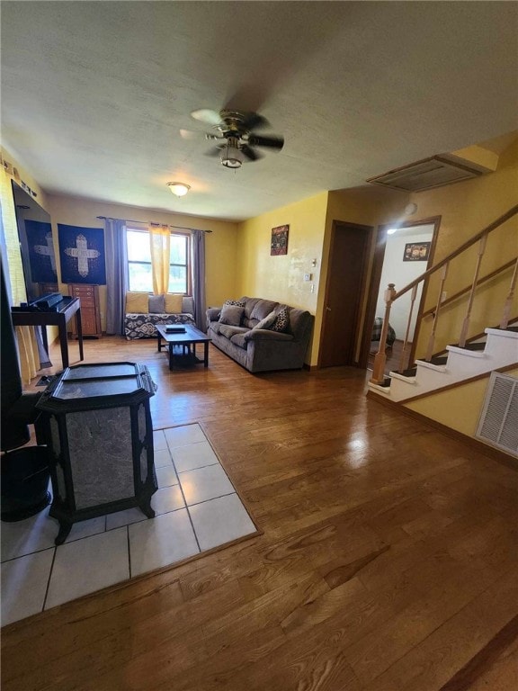 46 Hathcoat Rd, Harrison, AR 72601 - living room with wood finished floors, ceiling fan, stairs, and a wood stove