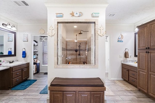 21018 Farm Rd Unit 2260, Eagle Rock, MO 65641 - full bathroom with a textured ceiling, wood tiled floors, two vanities, ornamental molding, and a tile shower
