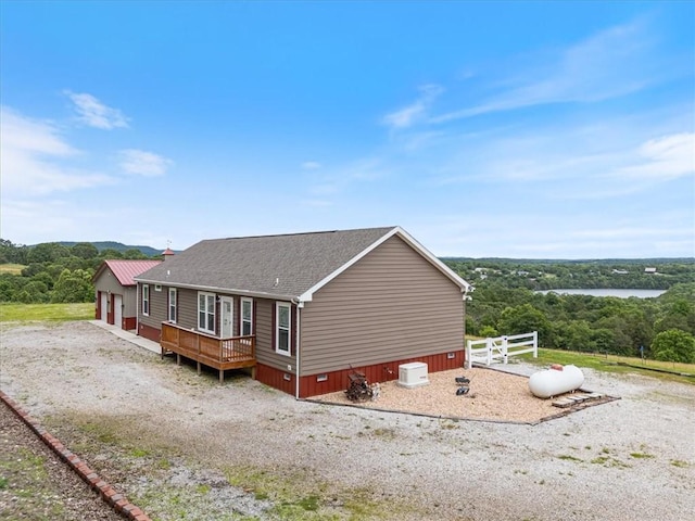 21018 Farm Rd Unit 2260, Eagle Rock, MO 65641 - view of property exterior featuring a wooden deck, a shingled roof, and a forest view