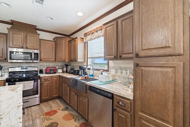 21018 Farm Rd Unit 2260, Eagle Rock, MO 65641 - kitchen with stainless steel appliances, tasteful backsplash, ornamental molding, light stone counters, and brown cabinets