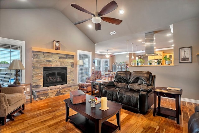 460 Viney Grove Rd, Prairie Grove, AR 72753 - living area with a ceiling fan, a stone fireplace, high vaulted ceiling, and wood finished floors