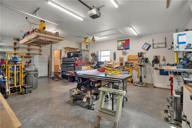 460 Viney Grove Rd, Prairie Grove, AR 72753 - garage featuring freestanding refrigerator, a workshop area, and a garage door opener