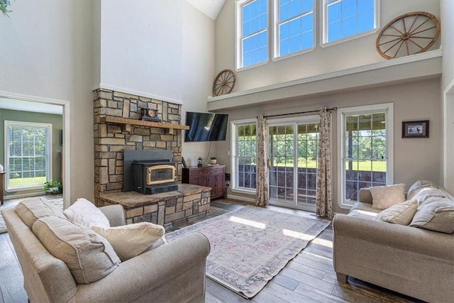 2042 Greasy Creek Ln, Washburn, MO 65772 - living room featuring a towering ceiling, wood finished floors, plenty of natural light, and a wood stove