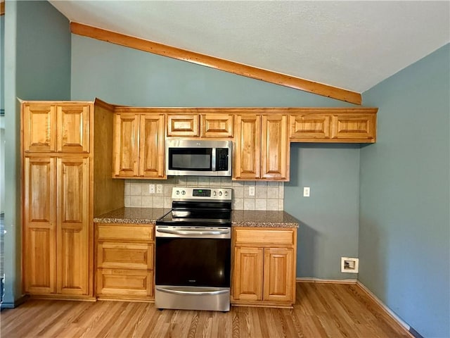14076 Canal St, Rogers, AR 72758 - kitchen with stainless steel appliances, vaulted ceiling, light wood-type flooring, backsplash, and dark stone countertops