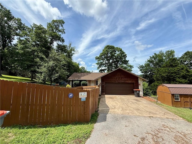 14076 Canal St, Rogers, AR 72758 - view of front facade featuring concrete driveway, an attached garage, and a storage shed