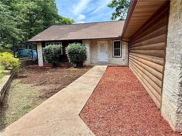 14076 Canal St, Rogers, AR 72758 - view of exterior entry featuring a shingled roof and faux log siding