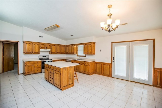 5315 Walden St, Lowell, AR 72745 - kitchen with electric range, brown cabinetry, lofted ceiling, light countertops, and under cabinet range hood