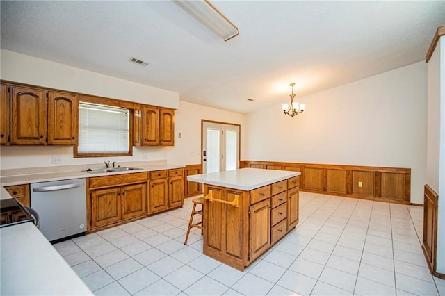 5315 Walden St, Lowell, AR 72745 - kitchen featuring dishwasher, brown cabinetry, wainscoting, light countertops, and a kitchen island