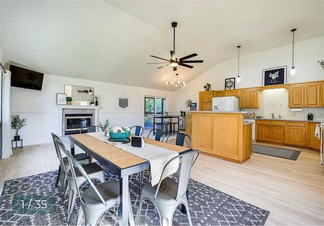 5 Horseshoe Dr, Holiday Island, AR 72631 - dining area with light wood finished floors, a ceiling fan, a glass covered fireplace, and high vaulted ceiling