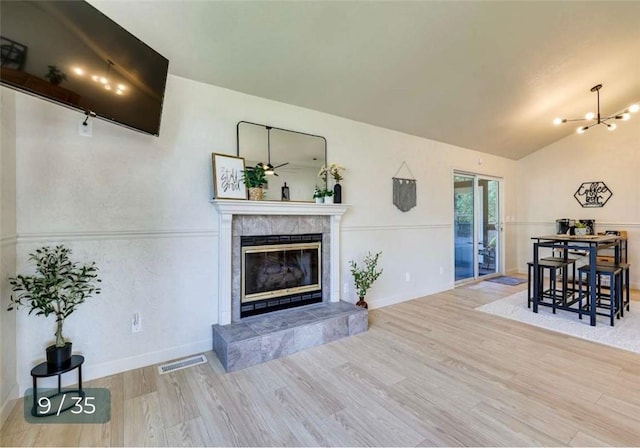 5 Horseshoe Dr, Holiday Island, AR 72631 - living area featuring wood finished floors, a fireplace, a chandelier, and lofted ceiling