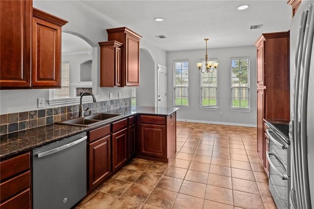 4788 Soapstone Dr, Fayetteville, AR 72704 - kitchen featuring appliances with stainless steel finishes, a chandelier, recessed lighting, light tile patterned floors, and a peninsula