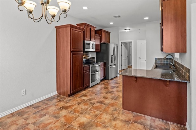4788 Soapstone Dr, Fayetteville, AR 72704 - kitchen featuring stainless steel appliances, a chandelier, dark stone countertops, a peninsula, and recessed lighting
