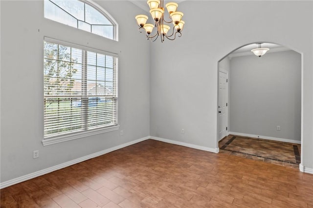 4788 Soapstone Dr, Fayetteville, AR 72704 - unfurnished room featuring arched walkways, a chandelier, and wood finished floors