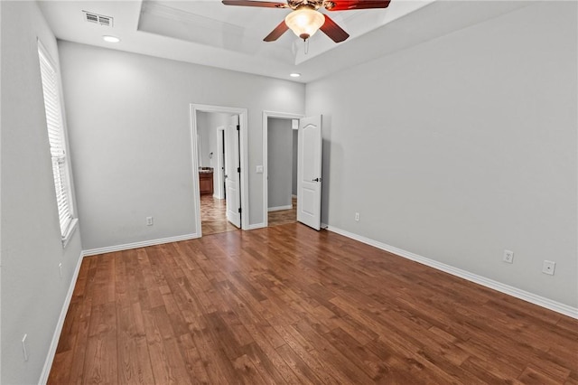 4788 Soapstone Dr, Fayetteville, AR 72704 - unfurnished bedroom featuring a raised ceiling, wood finished floors, recessed lighting, connected bathroom, and ceiling fan