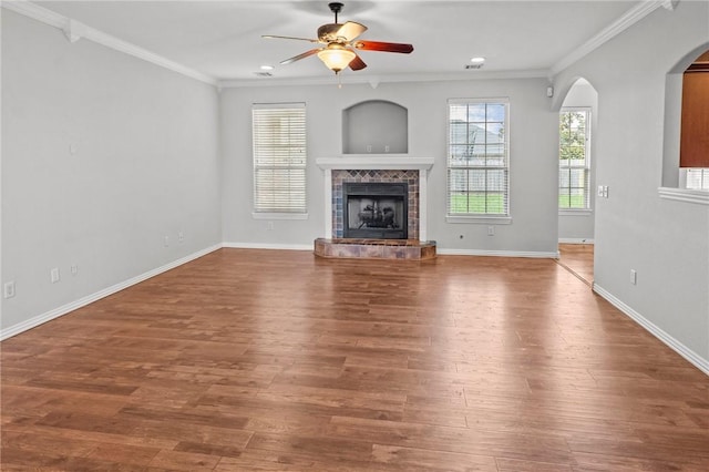 4788 Soapstone Dr, Fayetteville, AR 72704 - unfurnished living room with a ceiling fan, a fireplace, wood finished floors, crown molding, and arched walkways