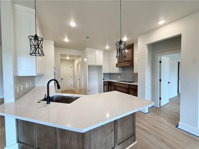 1215 John Renfro Rd, Pea Ridge, AR 72751 - kitchen featuring a peninsula, recessed lighting, tasteful backsplash, black electric stovetop, and light wood-type flooring