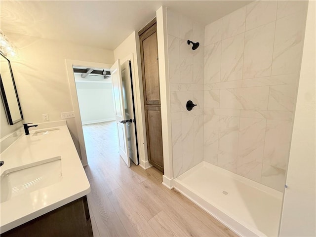 1215 John Renfro Rd, Pea Ridge, AR 72751 - full bathroom with double vanity, a tile shower, and wood finished floors