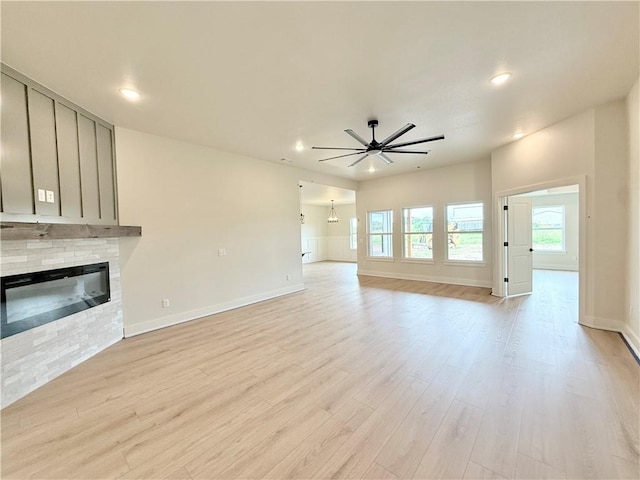1215 John Renfro Rd, Pea Ridge, AR 72751 - unfurnished living room featuring a ceiling fan, a glass covered fireplace, light wood-style floors, and recessed lighting