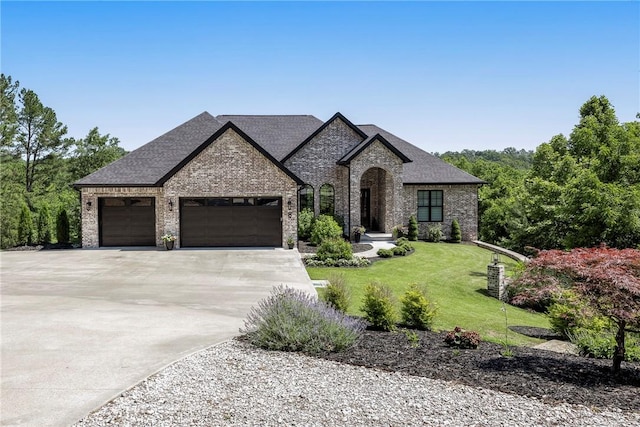 8 Mckenzie Way, Bella Vista, AR 72715 - french country home featuring a garage, driveway, brick siding, a front yard, and a shingled roof
