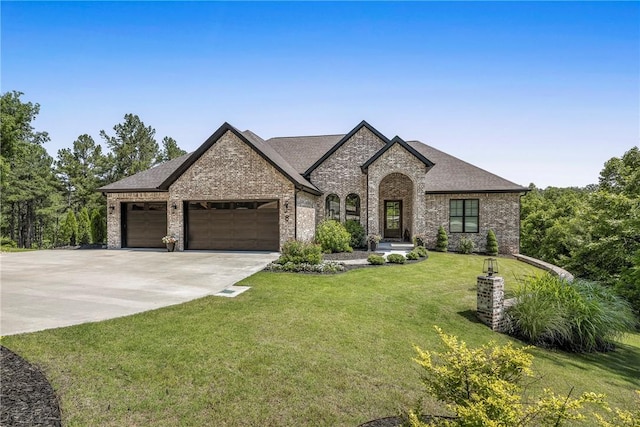 8 Mckenzie Way, Bella Vista, AR 72715 - french country style house with brick siding, a garage, a front yard, driveway, and roof with shingles