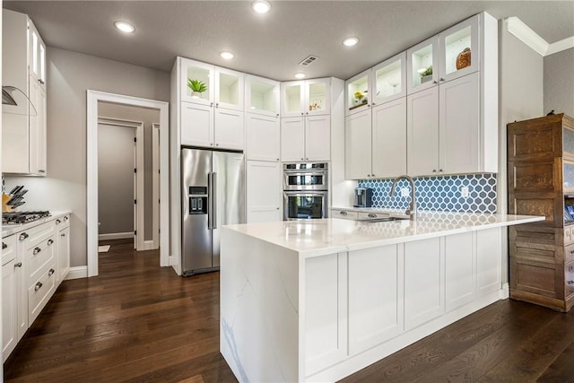 8 Mckenzie Way, Bella Vista, AR 72715 - kitchen with stainless steel appliances, a peninsula, dark wood-type flooring, white cabinets, and recessed lighting