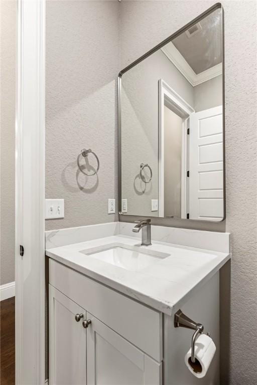8 Mckenzie Way, Bella Vista, AR 72715 - bathroom featuring vanity, a textured wall, crown molding, and wood finished floors