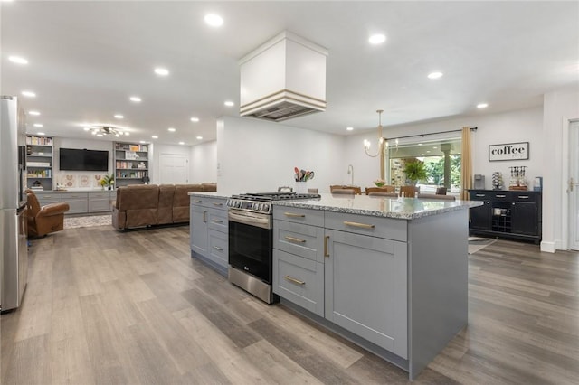 3902 Layton Dr, Harrison, AR 72601 - kitchen featuring appliances with stainless steel finishes, gray cabinets, wood finished floors, light stone countertops, and a kitchen island