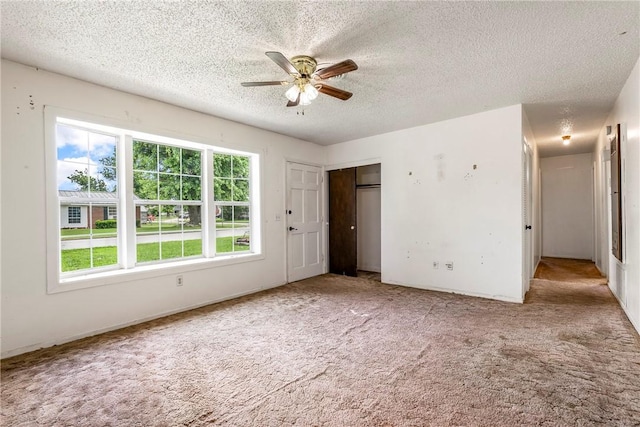 2000 W Wood St, Rogers, AR 72756 - unfurnished bedroom featuring a textured ceiling, carpet floors, a closet, and a ceiling fan