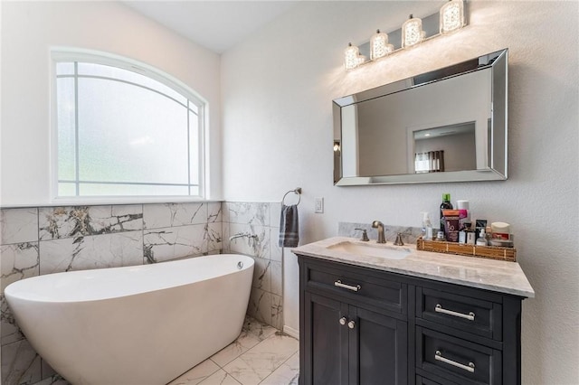 1209 W Olive St, Rogers, AR 72756 - bathroom with tile walls, marble finish flooring, vanity, a freestanding bath, and a wainscoted wall