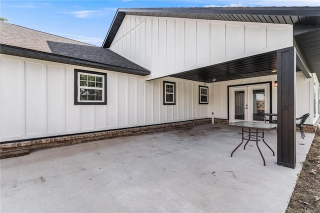 1209 W Olive St, Rogers, AR 72756 - back of property with board and batten siding, french doors, a shingled roof, and a patio