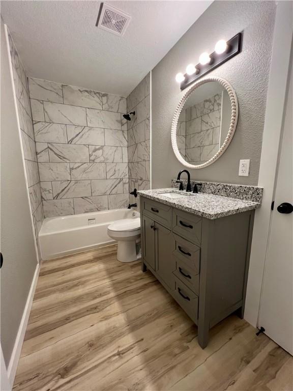 3501 Pleasant, Ozark, AR 72949 - full bathroom with vanity, wood finished floors, bathtub / shower combination, and a textured ceiling