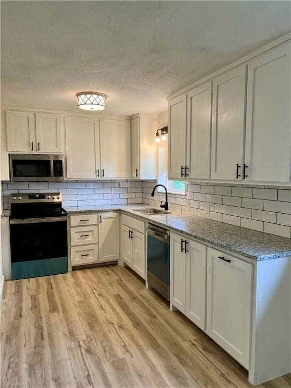 3501 Pleasant, Ozark, AR 72949 - kitchen featuring appliances with stainless steel finishes, decorative backsplash, white cabinets, and light stone countertops