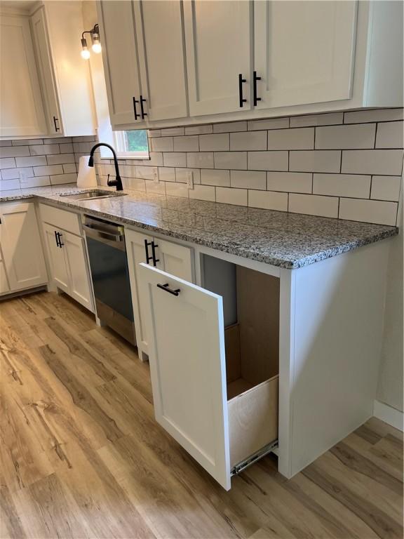 3501 Pleasant, Ozark, AR 72949 - kitchen featuring stainless steel dishwasher, light wood finished floors, white cabinetry, and light stone countertops