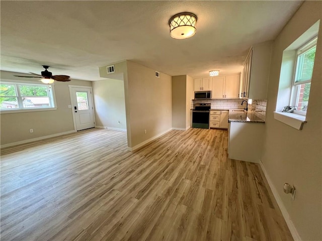 3501 Pleasant, Ozark, AR 72949 - kitchen with stainless steel appliances, open floor plan, light wood-style floors, decorative backsplash, and ceiling fan