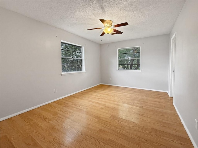 1906 S W End St, Springdale, AR 72764 - empty room featuring healthy amount of natural light, a ceiling fan, light wood-type flooring, and a textured ceiling