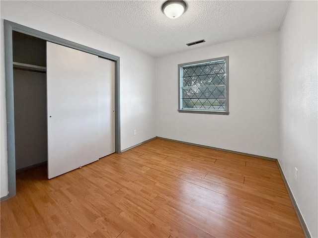 1906 S W End St, Springdale, AR 72764 - unfurnished bedroom featuring a textured ceiling, light wood finished floors, and a closet