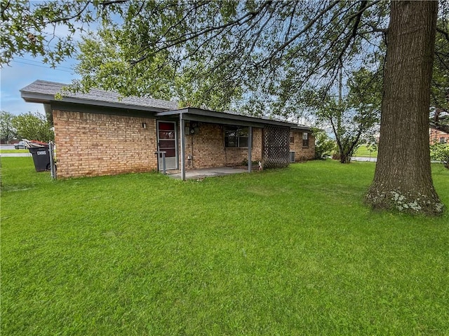 1906 S W End St, Springdale, AR 72764 - back of property featuring a yard, brick siding, and a patio area